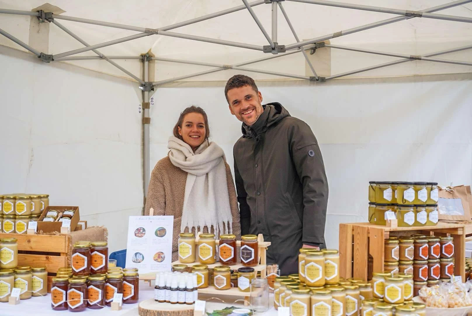 Thomas Josse, apiculteur et fondateur d’Abellia, et sa compagne sur un stand de vente de miels artisanaux pendant l’hiver.